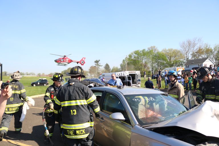 Fire and Emergency Personnel working at a mock car crash scene being staged to show students about impaired driving.