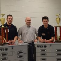 Ben, Zach and teacher Rob Schwarz with their winning first place trophies