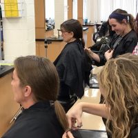 Image of 2 Cosmetology students cutting the 9" pont tails