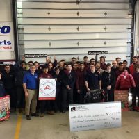 All of the automotive student and their teachers in a group photo presenting the check to Auto Dealers