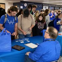 Quakertown Community High School students gather around a table to speak with a business representative about potential employment opportunities.
